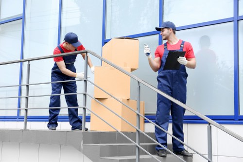 Professional movers preparing furniture with safety equipment