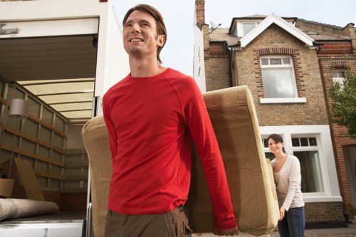 Upright piano being moved safely through a Wimbledon property